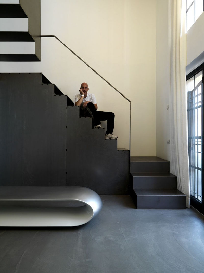 This large black staircase was designed with cut outs at the back of each step to allow light to pass through and help brighten the space while still maintaining an industrial look.