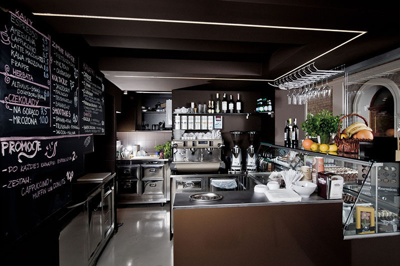 The service area in this modern chocolate shop and cafe is tucked beside a set of stairs and underneath a mezzanine level.