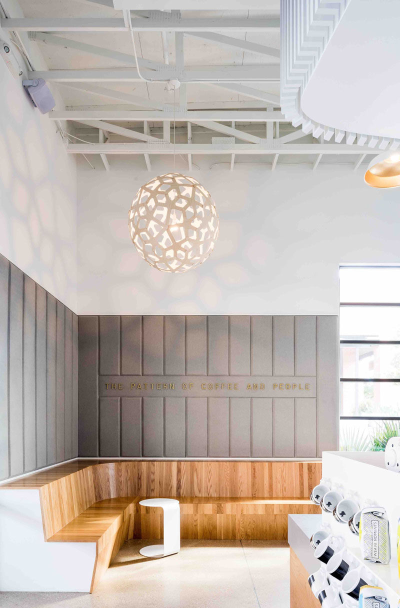 This modern coffee shop has built-in wooden banquette that curves around the corner to create plenty of seating.