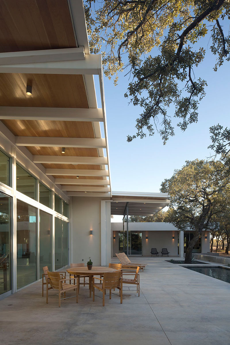 This modern house in Texas has a large overhang that provides shelter and shade when you need it but also lets light into the home through the large floor-to-ceiling windows.