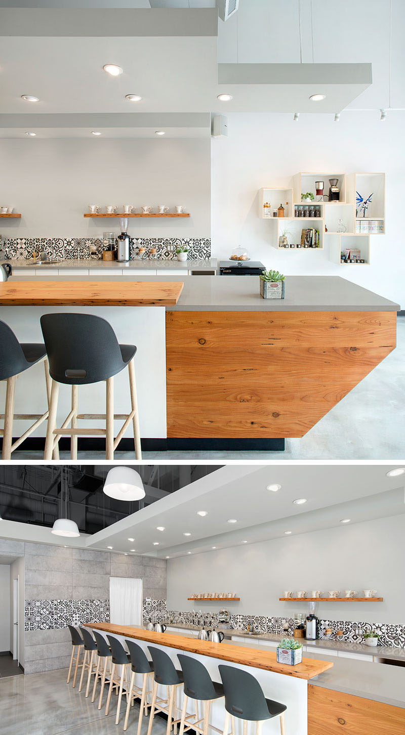 This modern coffee shop that serves hand poured coffees, has an large bar made from wood and a grey engineered stone countertop.