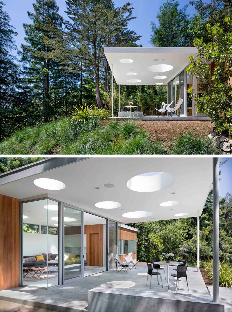 At the front of this modern guesthouse is a covered outdoor porch. The flat roof of the guesthouse has different sized circle skylights, that provide a playful pattern when viewed from the main house below.