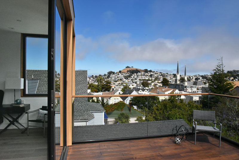 The top level of this modern home there's a balcony that overlooks the backyard and the neighborhood.