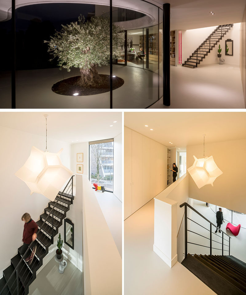 Simple black steel stairs lead to the upper floor of this modern house, and are a strong contrast to the white walls of the home.