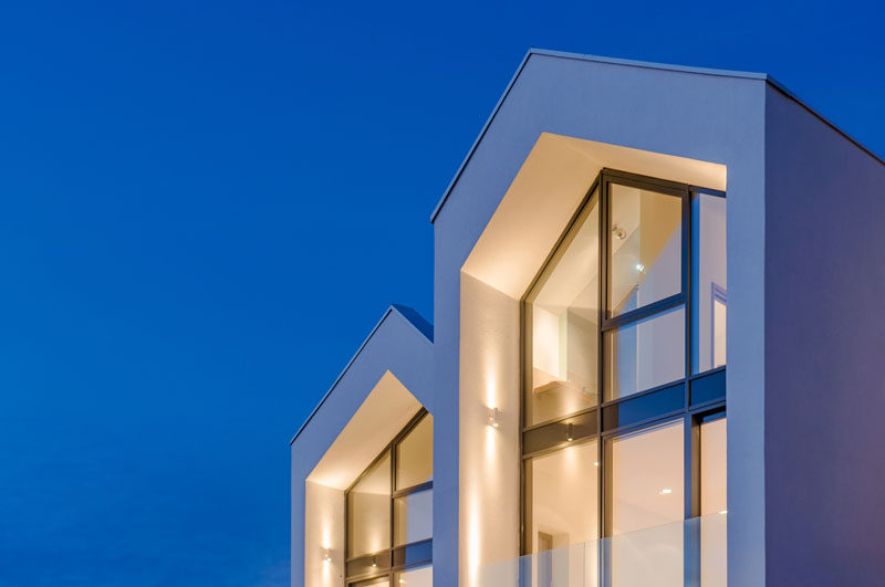 This modern house has a gabled roof and black framed windows that follow the roof line.