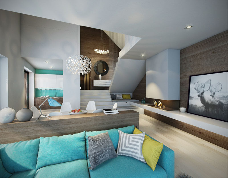 In this modern open plan interior, a turquoise couch matches the pop of blue in the kitchen and breaks up the mostly white and wood interior.