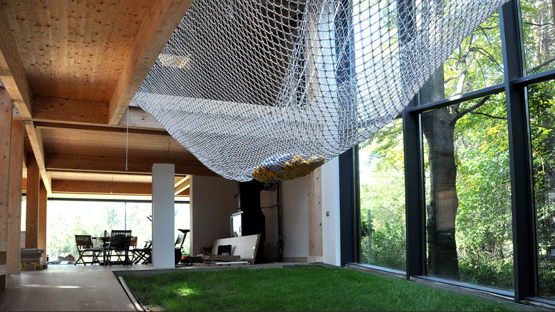 The large net in this home allows loungers to feel like they're actually hanging outside in a hammock thanks to the floor to ceiling windows on one side and the patch of real grass underneath.