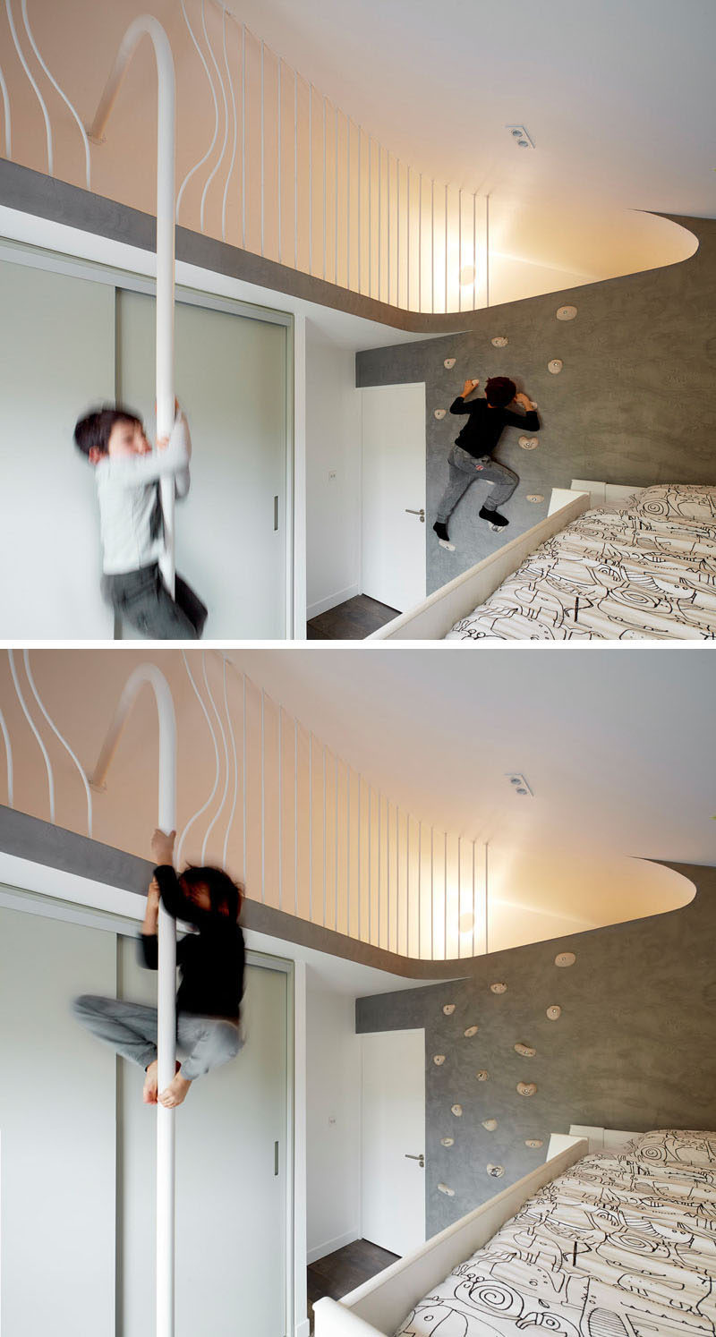 In this kids bedroom, a rock climbing wall lets the children climb up to a lofted area where they can slide down a pole to get down. #RockClimbingWall #InteriorRockClimbingWalls #InteriorDesign