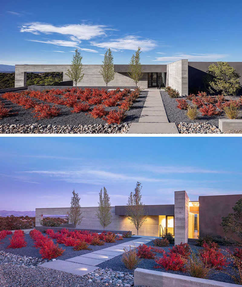 The curb appeal of this modern house features rows of colorful plants and dark gravel, that help to making the path to the front door stand out. 