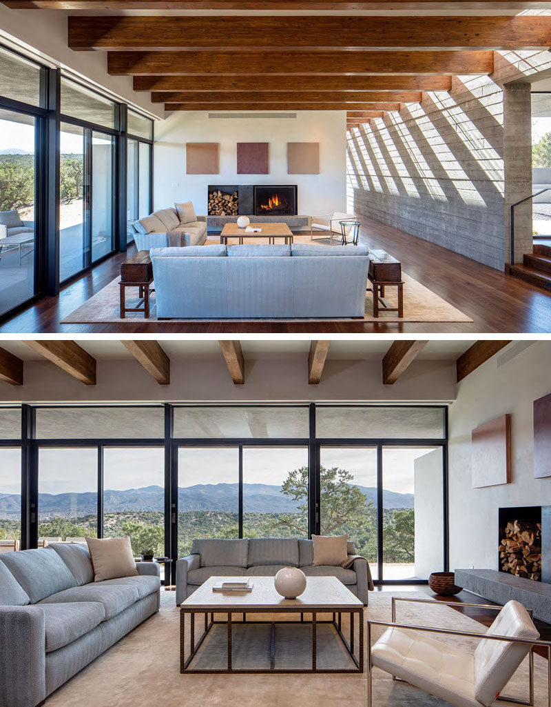 This modern living room is focused on the fireplace and has sliding glass doors that open up to the shaded porch outside. 