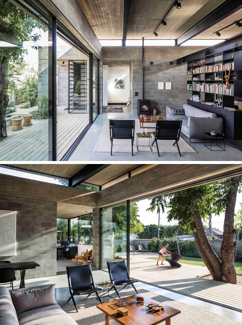 The main living area of this modern house is open to the yard, and the raw concrete compliments the black metal work in the beams and the built-in bookshelf. The thin concrete roof hovers above the living space, while small windows provide a constant glimpse of the sky, even when inside.