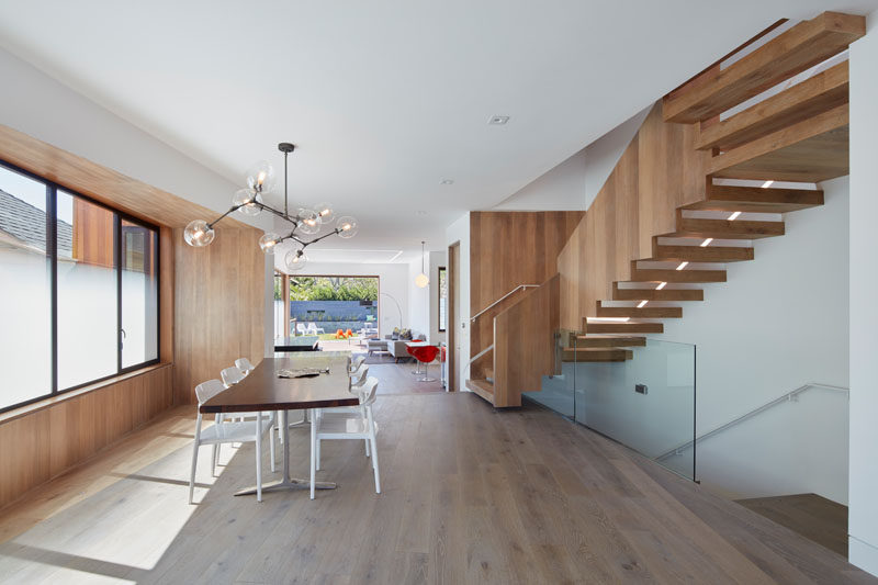 This dining area features a simple live-edge wood dining table and a sculptural chandelier that anchors it in the open floor plan.