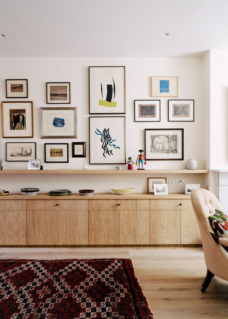 This gallery wall combines modern art with old photographs and maps to create a contemporary display that shows off the home owner's many interests.