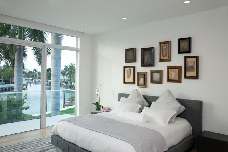 A collection of vintage art pieces hang above the bed in this modern bedroom adding a touch of personality to the space, and demonstrating how the old and the new can be used together to create a contemporary look.