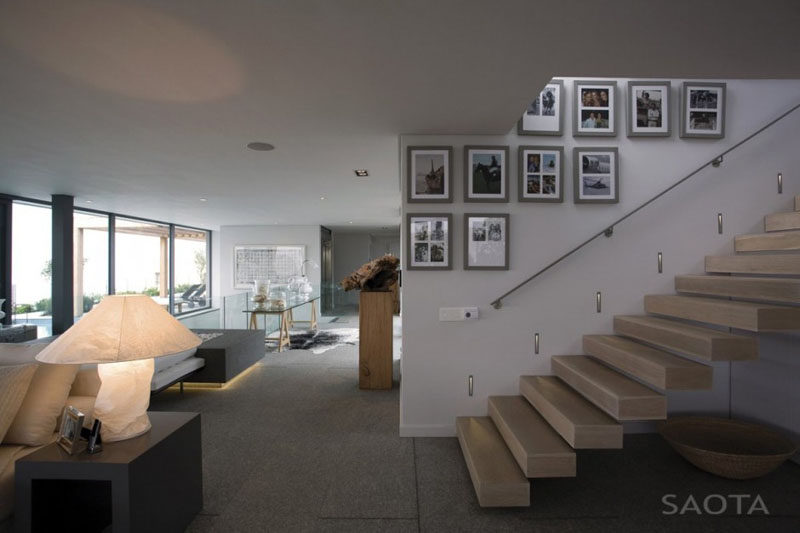 Photos in simple grey frames lead up the stairs of this home and create a simple gallery wall full of memories.