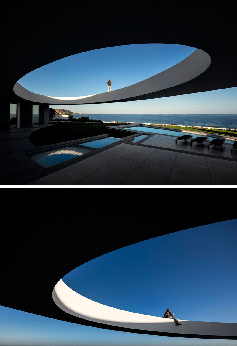 This modern house has a large ellipse cut out of a section of the design to create a sculptural design.