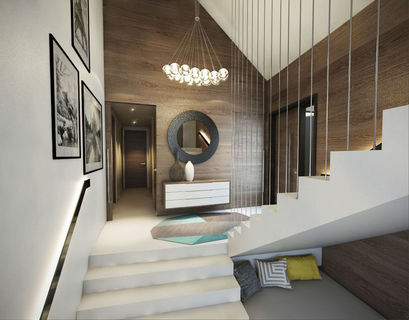 Inside this modern house, the wood walls create a natural warmth to the entryway, and white stairs direct you to the different areas of the home.