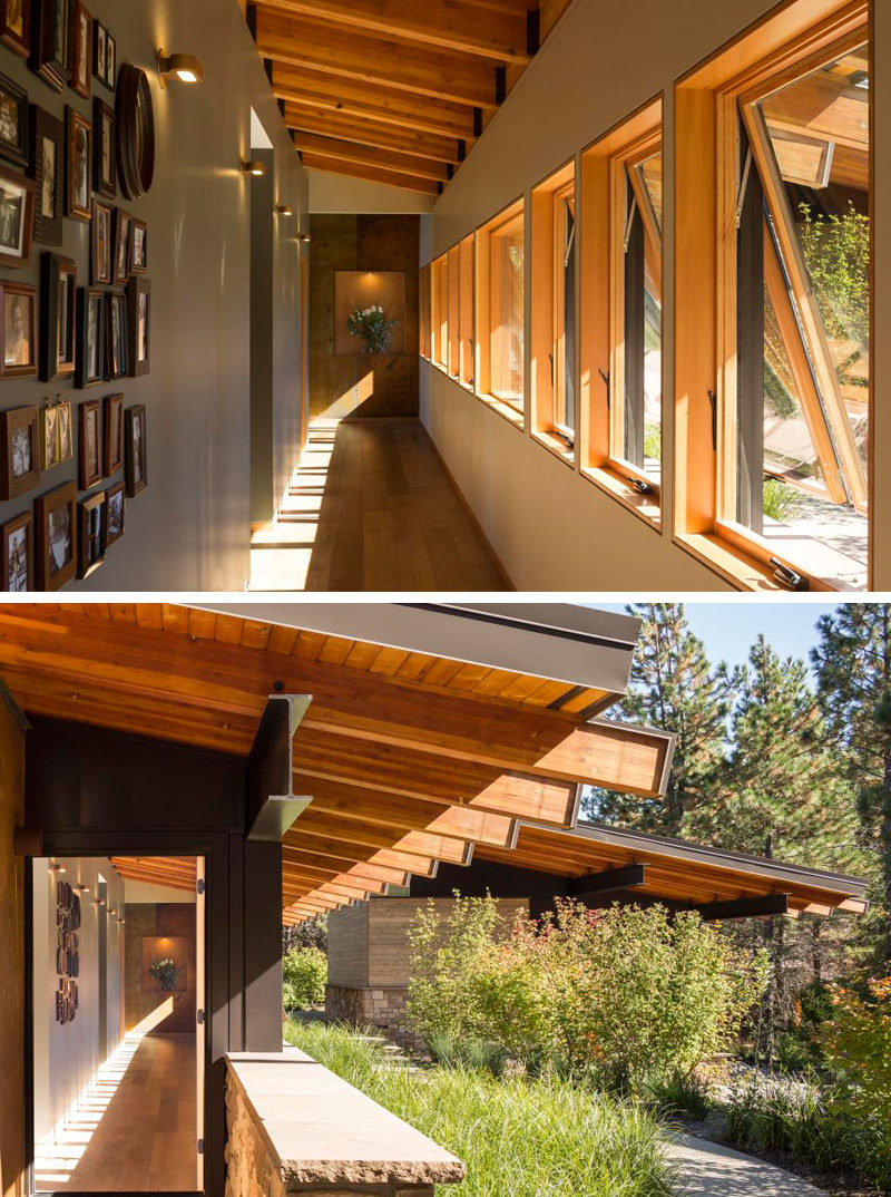 In this modern vacation home, a bright hallway, lined with windows and family photos, leads away from the main living area into the private spaces at the back of the cabin, and also leads back outside and connects to a path that runs around the exterior.