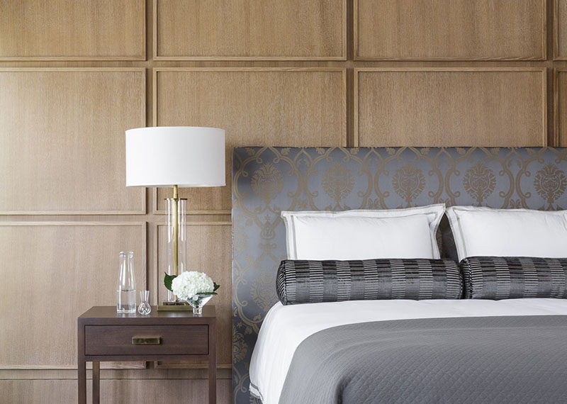 This contemporary bedroom uses square wood panels to create a modern accent wall behind the bed.