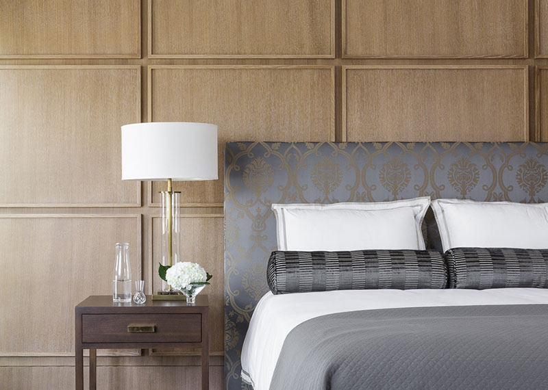 This bedroom uses square wood panels to create a modern accent wall