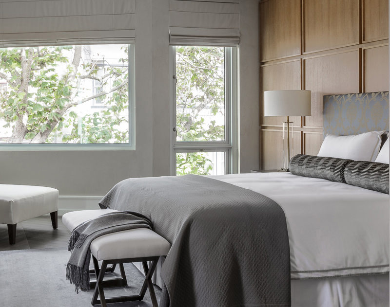 This contemporary bedroom uses square wood panels to create a modern accent wall behind the bed.