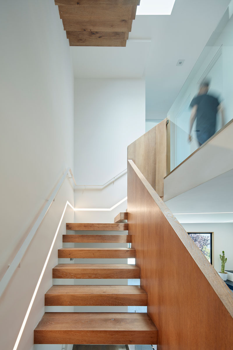 These modern wood stairs have a small light built into the wall that runs the length of the stairs.