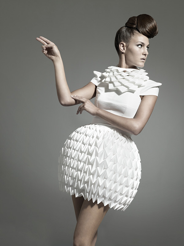 An intricately folded skirt and neckline give this origami-inspired white dress an artistic and futuristic look. #Fashion #Style #Origami #OrigamiFashion #Design