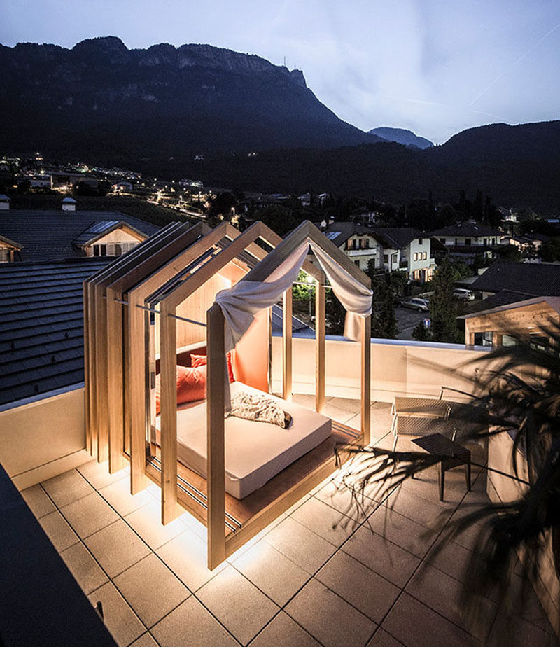 This modern outdoor rooftop bedroom with hidden lighting, has an extendable wood cabana that can be as open or closed as you want, allowing you to sleep under the stars.