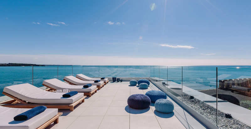 Glass panels surrounding this large rooftop deck filled with daybeds, to ensure that the views are never interrupted and that the sea breeze never gets in the way of rooftop sunbathing.