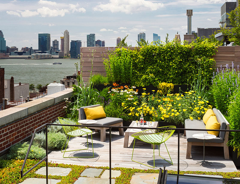 The rooftop of this New York warehouse turned residence has a lush garden filled with flowers and a cozy lounge area that provides an escape from the hustle of city living.