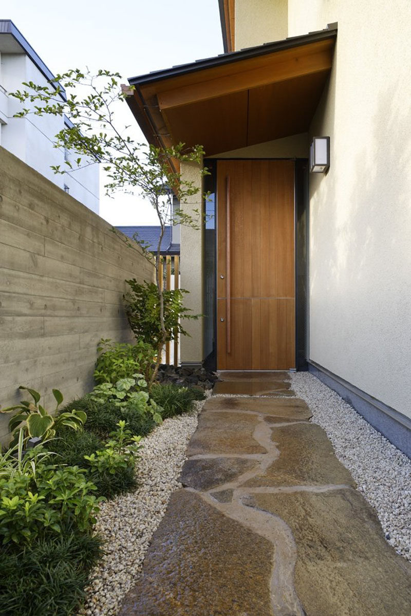 This tall wood Dutch door has an extra tall door handle split in two that allows the front door of this house to be opened completely or only partially.