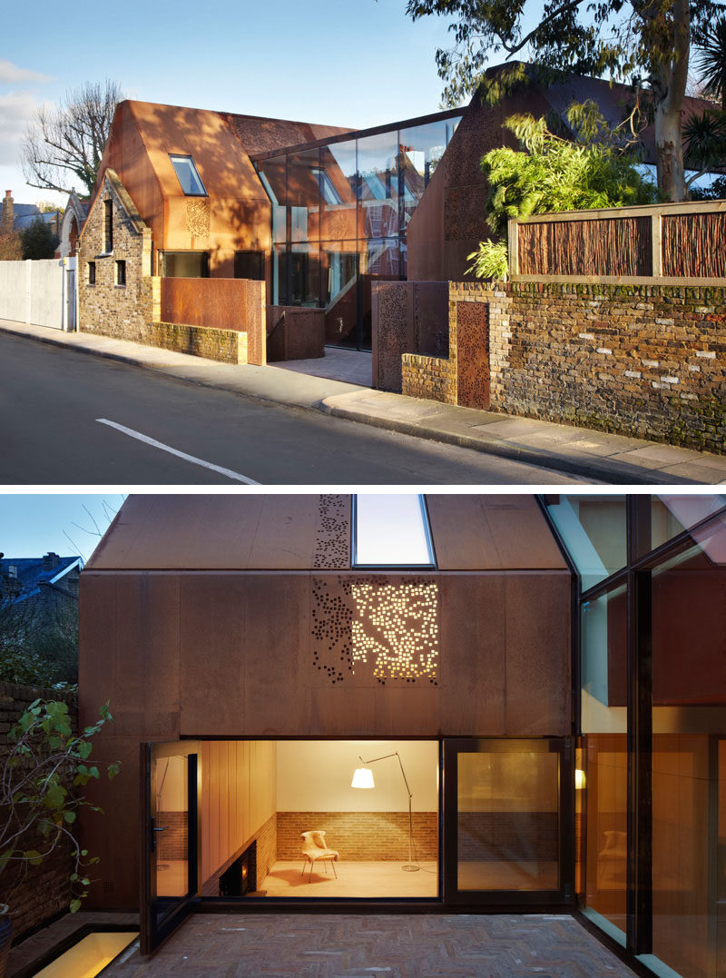 This home, built behind a 19th century stable wall, has a modern look to it created by the use of large glass panels and perforated weathering steel covering the exterior.