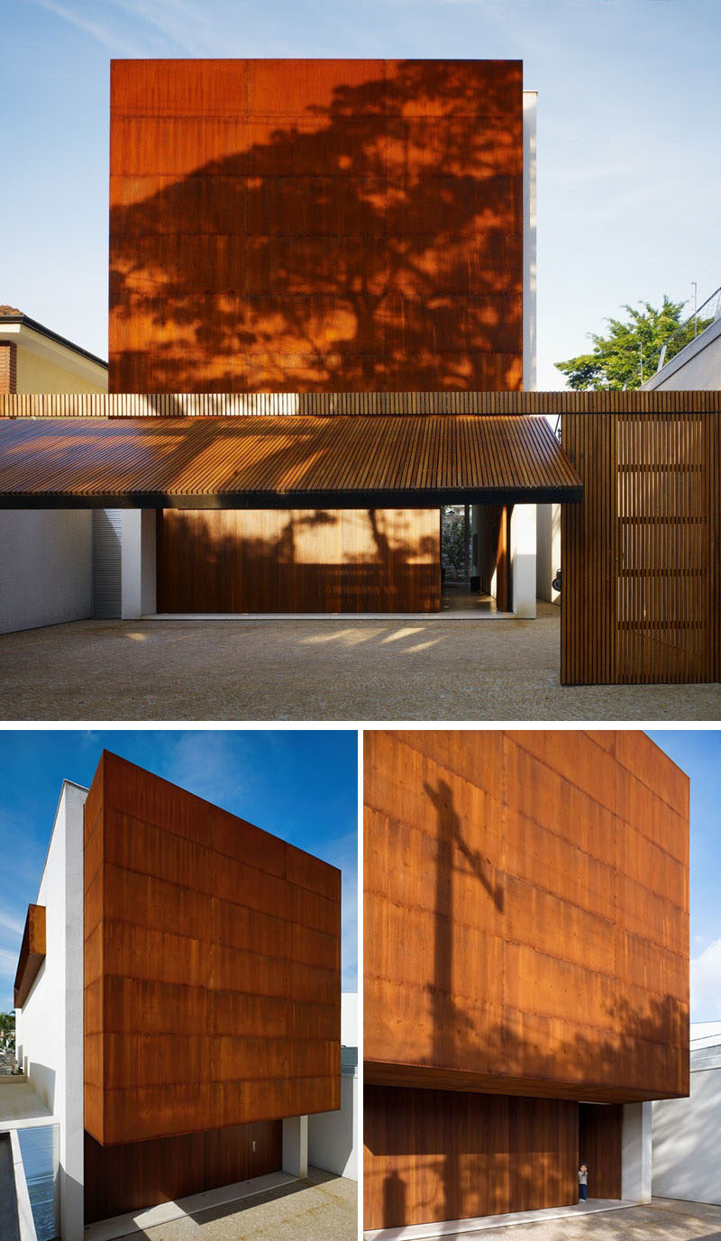 The weathering steel on the exterior of this modern house matches the tone of the wood used on the garage and front doors and gives the facade a textured and unique look.