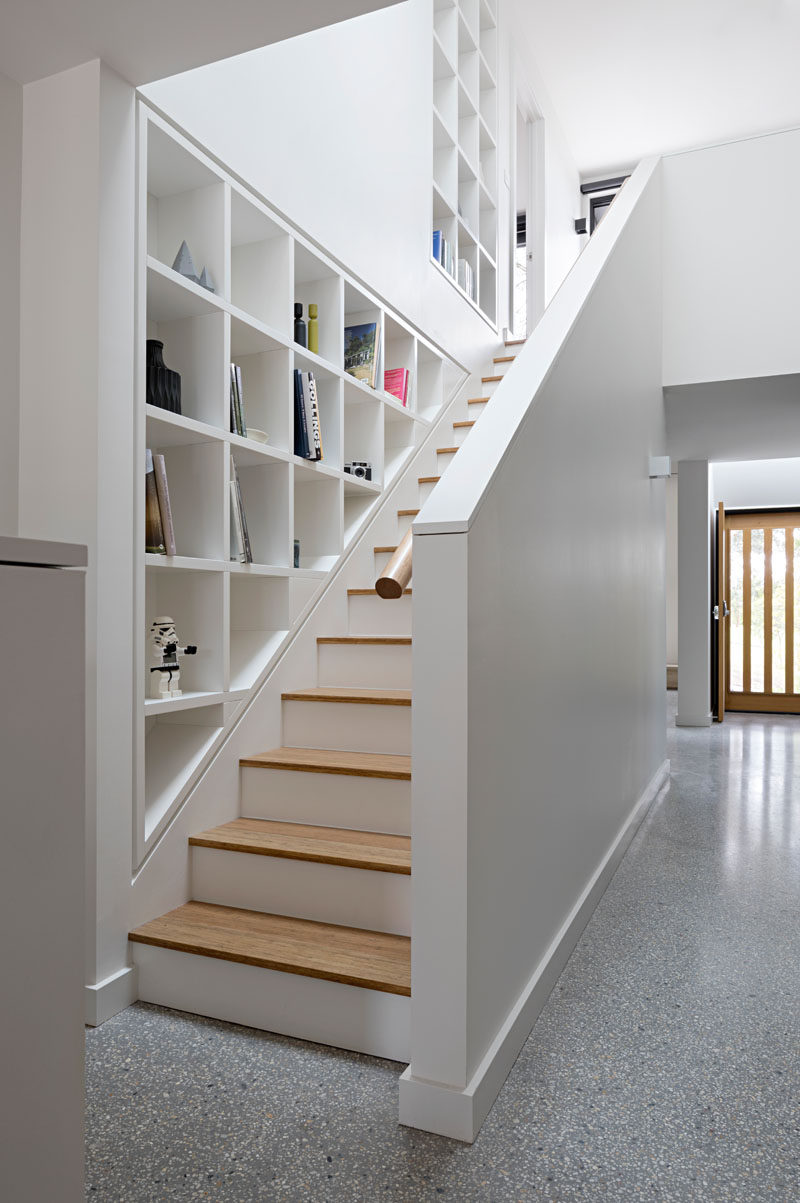 These white and wood stairs are lined with custom-designed shelving to display personal items, while the skylight above gives off plenty of natural light.