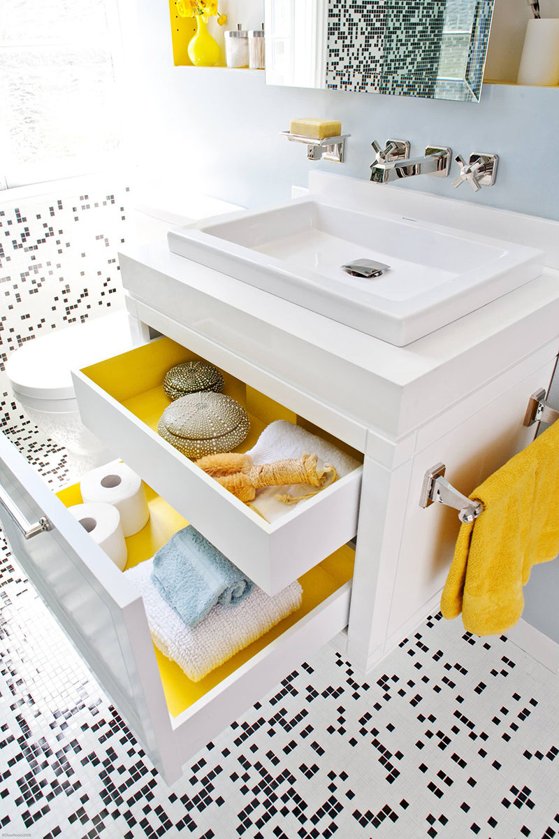 When the drawers in this modern bathroom are closed, the bathroom is primarily black and white with a couple of yellow accents creating an overall look of modern sophistication. But an unexpected pop of color can be seen when opening the drawers that have been painted yellow on the inside.
