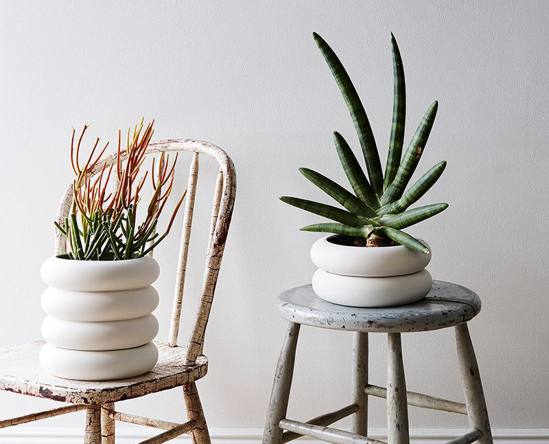 Chen Chen and Kai Williams have created a line of modern, white stacked porcelain planters that are inspired by the ceramic insulators that cover high-voltage power lines. The Power Planters have a pot and the drainage saucer that are both the same size, creating the look of stacked rings.