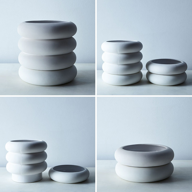 Chen Chen and Kai Williams have created a line of modern, white stacked porcelain planters that are inspired by the ceramic insulators that cover high-voltage power lines. The Power Planters have a pot and the drainage saucer that are both the same size, creating the look of stacked rings.