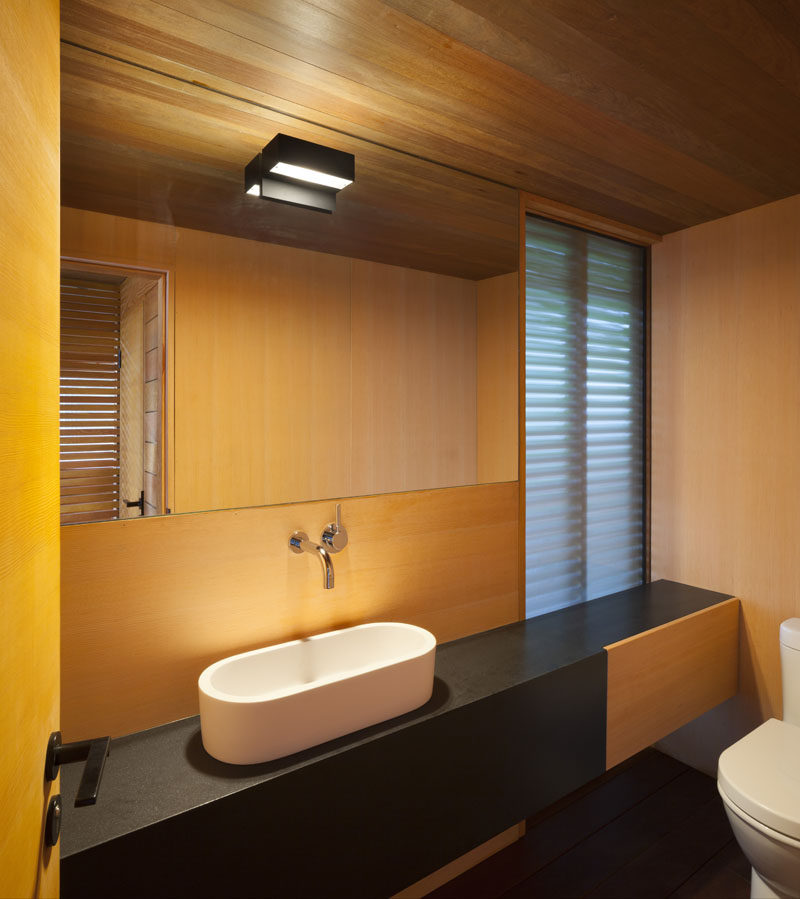 This modern pool house has a bathroom and change room with frosted glass panels, so that the natural light can still filter through to the interior of the pavilion.