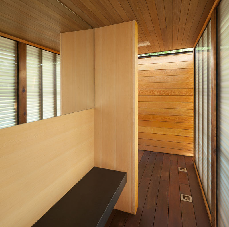 This modern pool house has a change room and shower, with frosted glass and wood slats providing some privacy.