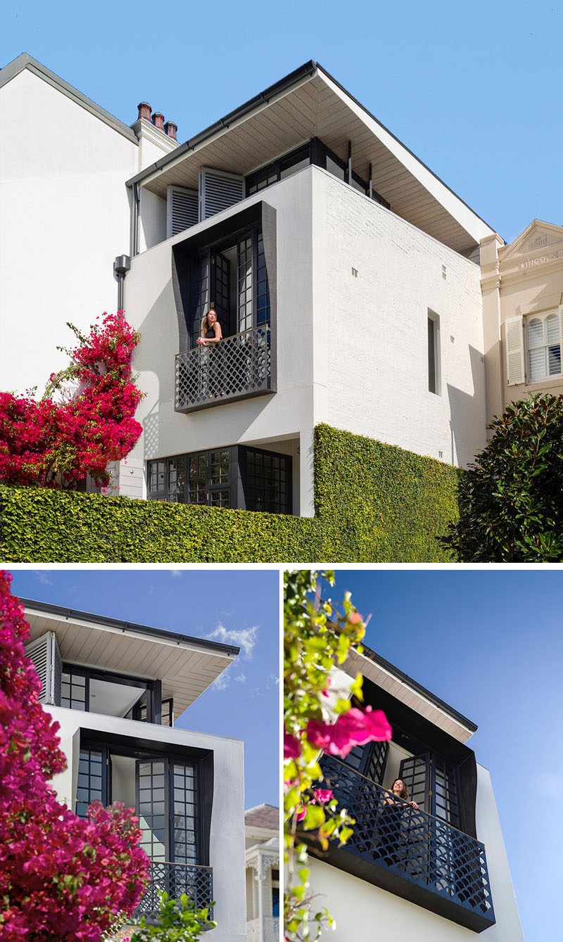 Stepping through to the front terrace of this modern house, there's a bright pink bougainvillea, and when it blooms it adds a bright pop of color to the white and black house.