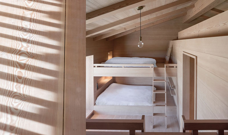 This modern Scandinavian inspired bedroom features built-in bunk beds and a small loft area.