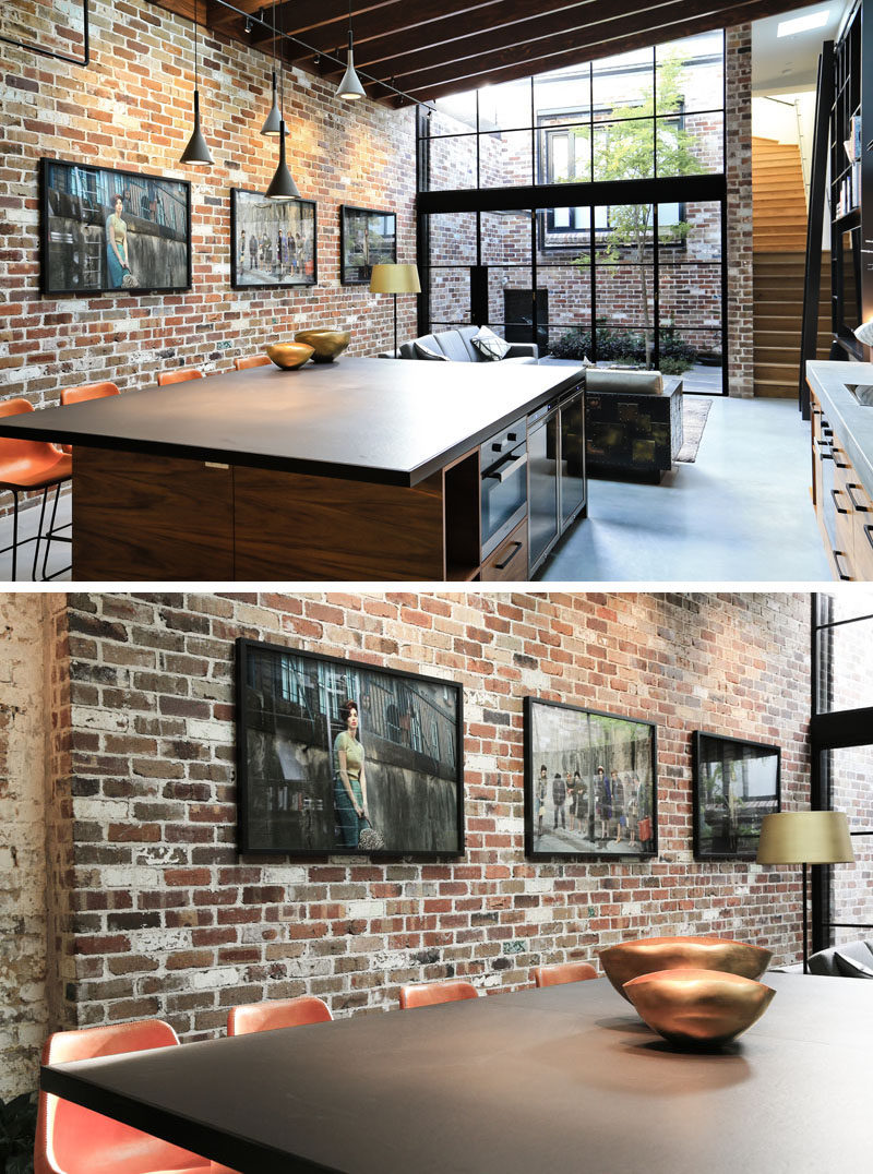 This large kitchen island features concrete pendant lights hanging above and plenty of room to seat four people. Behind the island and the living room, is a brick wall that ties back into the days when the space was used as a commercial garage. 