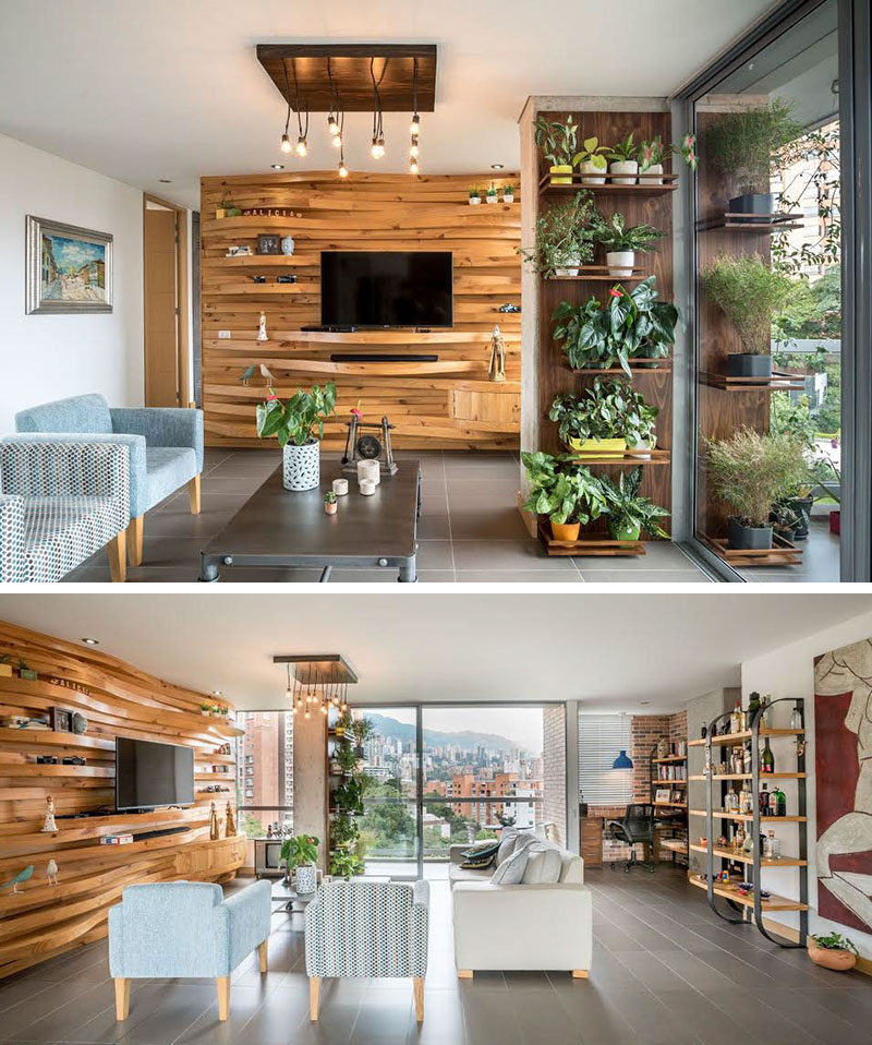 This modern apartment features a wavy wood accent wall that adds warmth to the interior, and also doubles as shelving for the television and decorative home decor items.