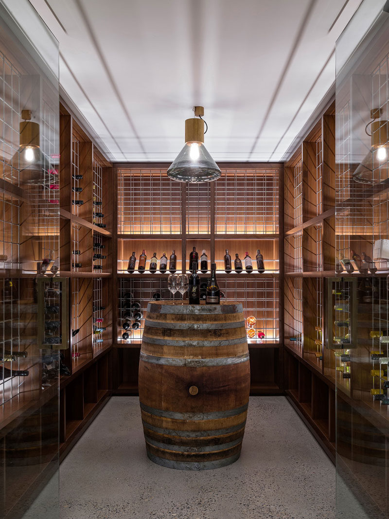 This custom wine cellar features a barrel as a table and hidden lighting to show off the bottles.
