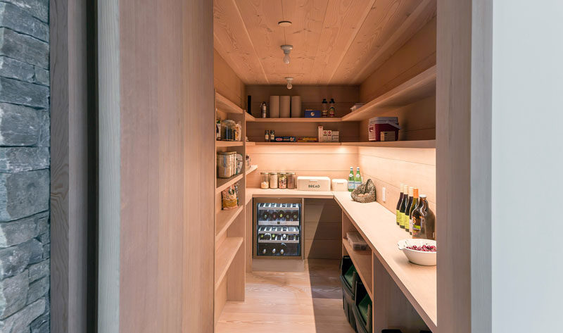 This large wood pantry has plenty of built-in shelves, counter space and a wine fridge.