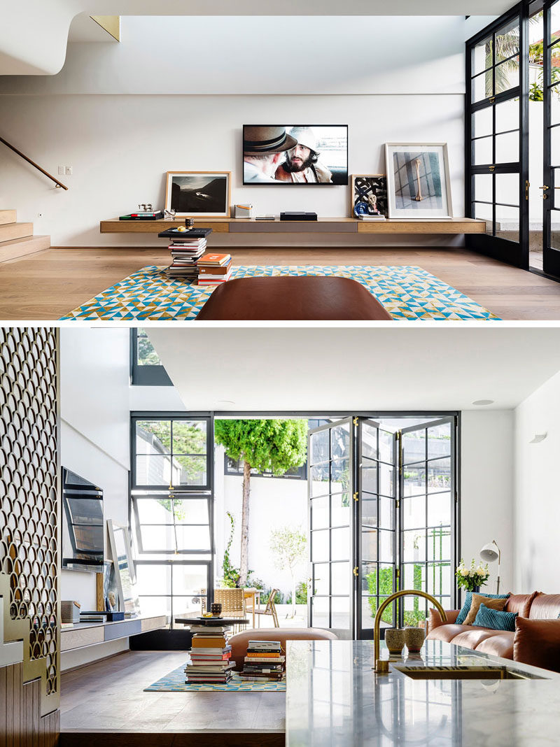 The living room in this modern house has the concrete bench from the courtyard flowing through to the interior where it becomes a floating shelf in the living room. 