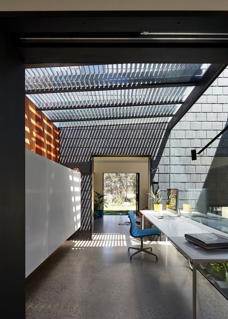 Separating various areas in this modern house is a home office that is flooded with natural light and looks out to the backyard.