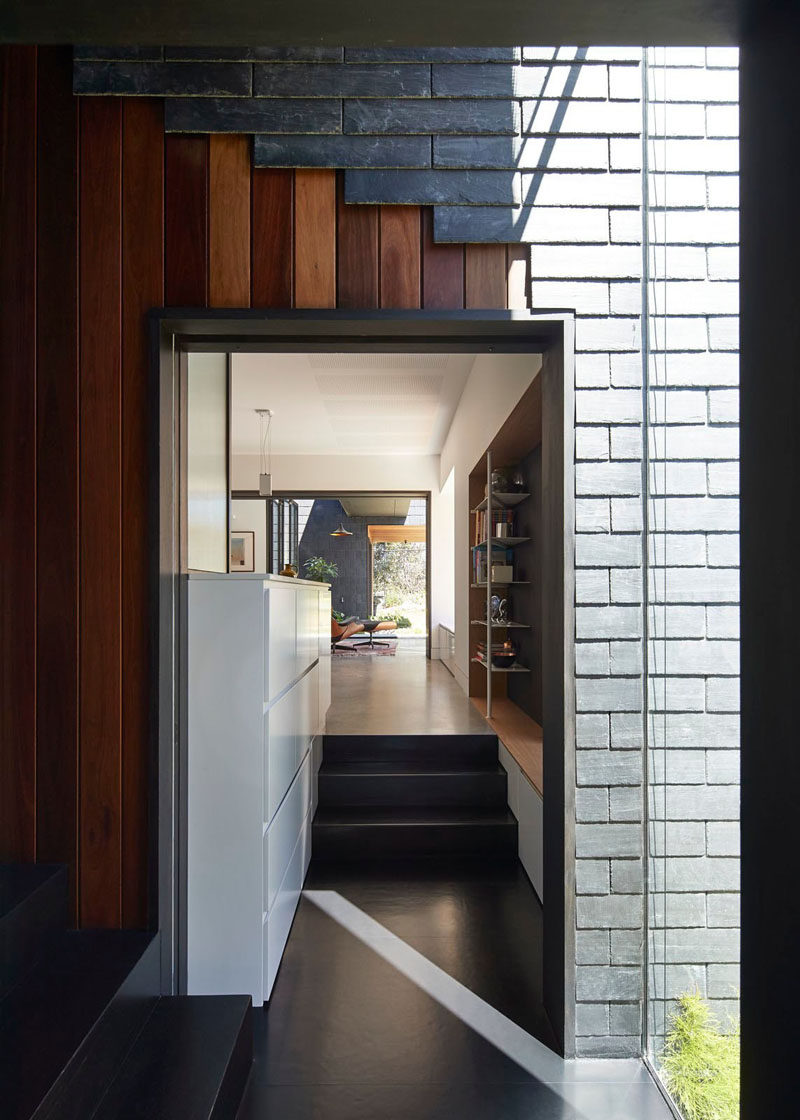 In some parts of the interior of this modern house, there are glimpses of the exterior materials (grey slate tiles and wood) flowing through to the interior.