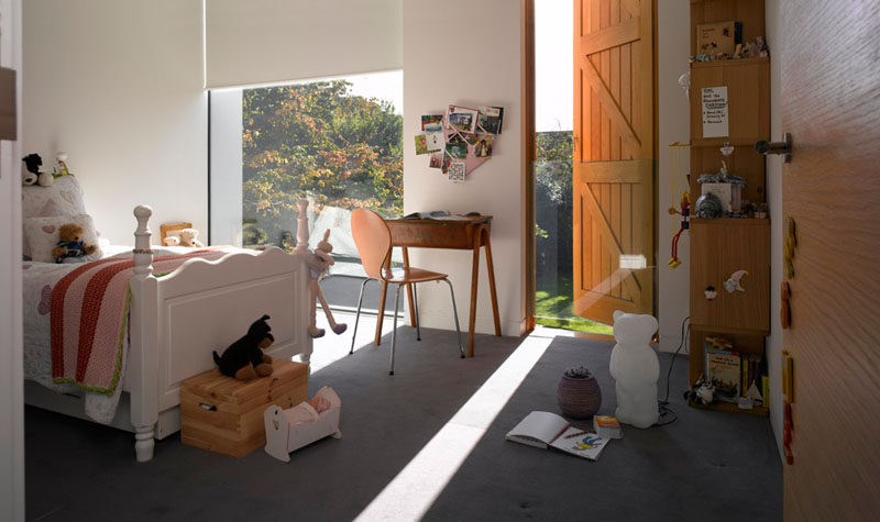 In this kids bedroom, white roll down blinds that match the walls are used for privacy.