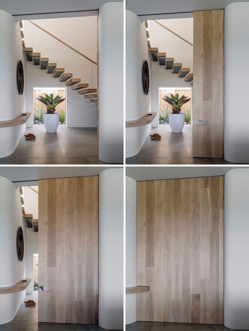 In this modern house, a large sliding wood door can be closed to hide the stairs and entryway from the main living space, while a continuous shelf between the two spaces is the ideal spot for dropping your keys and phone when you walk inside.